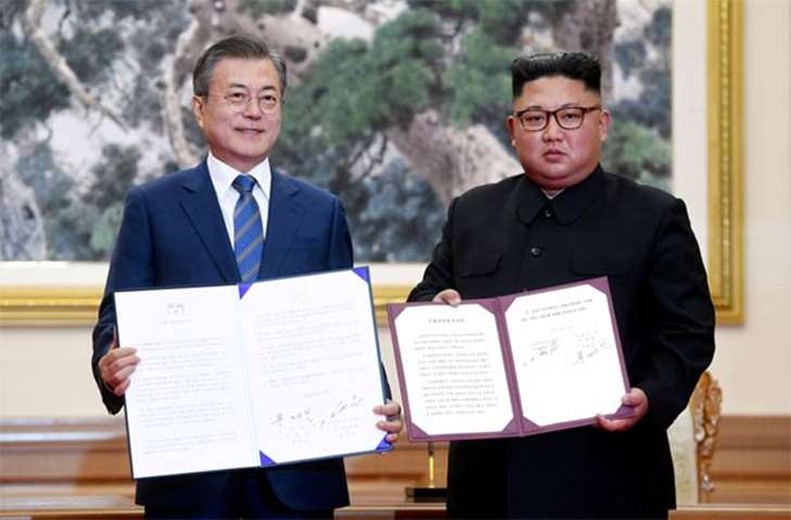 Moon Jae-in and Kim Jong Un pose for photographs with the joint statement