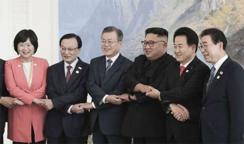 Moon Jae-in and Kim Jong Un are seen with a South Korean delegation after a luncheon