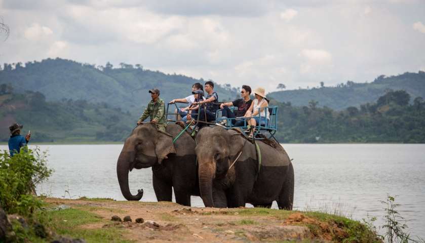 Tourists riding on elephants during a trek around Lak district