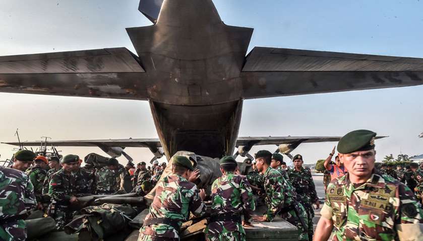 Indonesian soldiers load emergency supplies into a military plane before heading to quake hit Palu