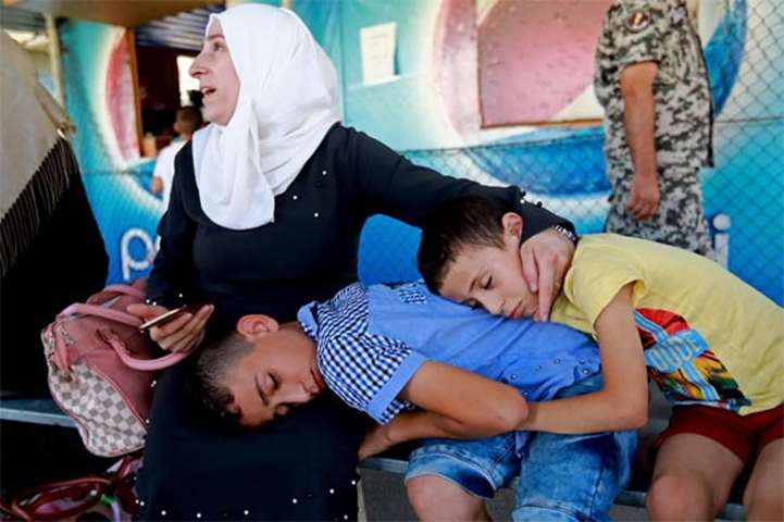 A mother waits along with children before leaving Beirut for Syria on Sunday