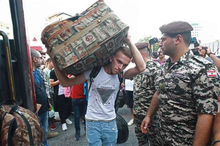 A Syrian man carries a luggage as refugees head home to Syria