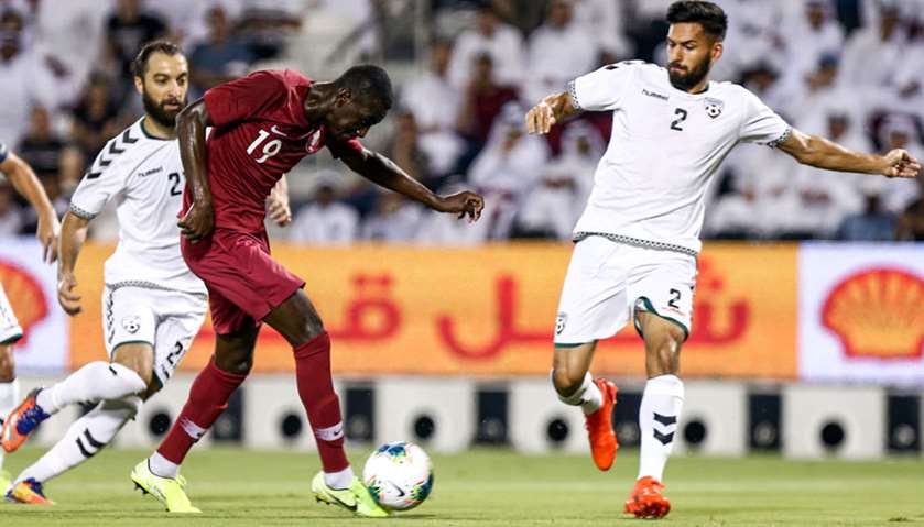 Qatar\'s forward Almoez Ali (C) vies for the ball against Afghanistan\'s midfielder Abassin Alikhil (R
