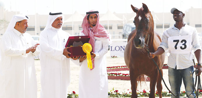 A winner at the Straight Egyptian Show receiving the winners trophy at the outdor arena of the Qatar Equestrian Federation yesterday. PICTURES: Juhaim