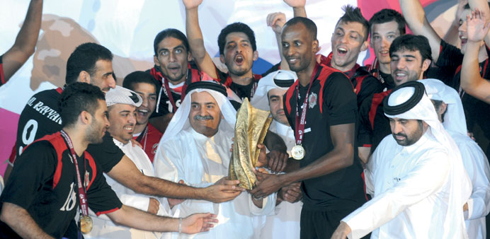 Victorious Rayyan team is handed over the Emir Cup volleyball trophy.