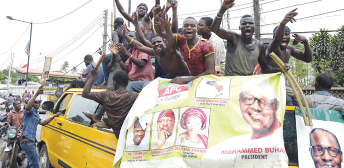 Supporters of newly-elected Nigerian President Muhammadu Buhari sit on top of a bus during celebrations in Lagos.