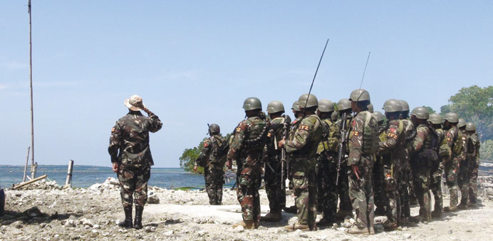 Government soldiers salute the Philippine national flag, after overrunning a command post of the rebels of the Moro National Liberation Front (MNLF) i