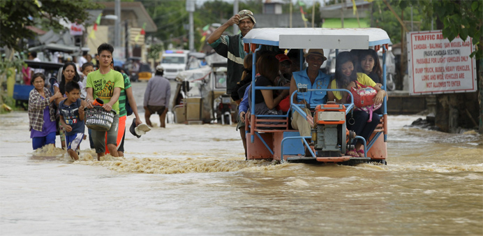 Residents wade through a flooded street after heavy rain at Candaba town, Pampanga province