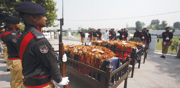 An honour guard in Peshawar stands watch yesterday over coffins of policemen martyred during anti-Taliban operations.