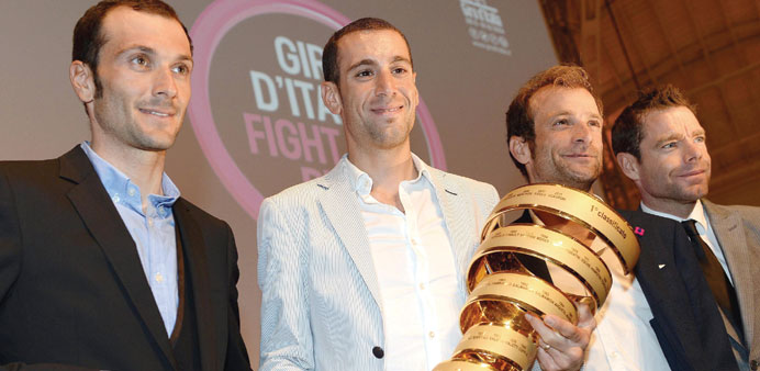 Italian riders Ivan Basso (L), Vincenzo Nibali (C), Michele Scarponi and Australiau2019s Cadel Evans (2nd R) pose with the winneru2019s trophy during the pres