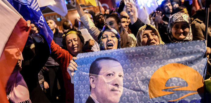 Supporters of Turkey's Justice and Development Party (AKP) wave party flags and hold a flag with a portrait of Turkish President Recep Tayyip Erdogan 