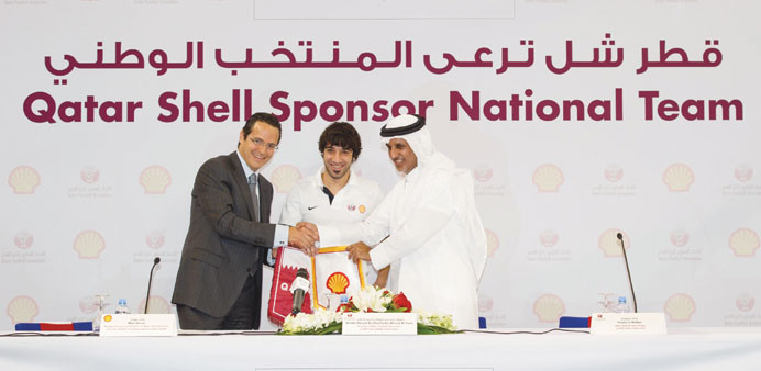 Qatar Football Association President Sheikh Hamad bin Khalifa bin Ahmad al-Thani (R), Qatar Shell MD Wael Sawan (L) and national team player Khaled Mu