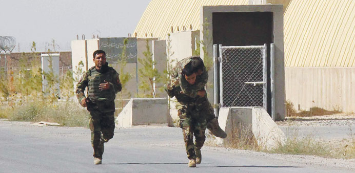 An Afghan National Army soldier carries an injured colleague during an offensive against the Taliban in Kunduz.