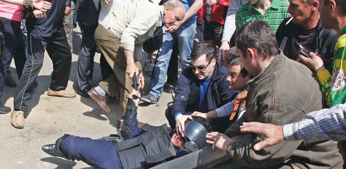 Pro-Russian separatists attack a police officer guarding the burned trade union building in Odessa.