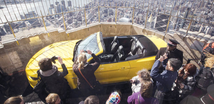 Tourists admire the new 2015 Ford Mustang GT on the observation deck of the Empire State Building in New York.