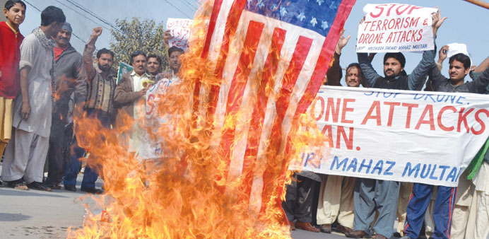 People burn a mock US flag during a protest against US drone attack in North-Waziristran tribal agency, in Multan, Pakistan, yesterday.