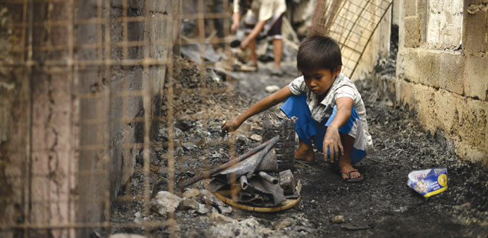 A child searches for recyclable materials after the fire.