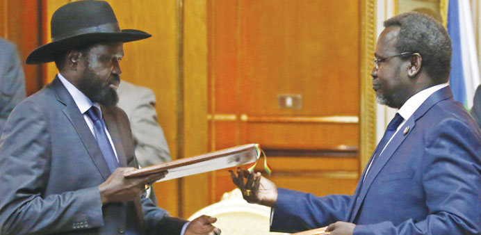 South Sudanu2019s President Salva Kiir and rebel leader Riek Machar exchange signed peace agreement documents in Addis Ababa on Friday.