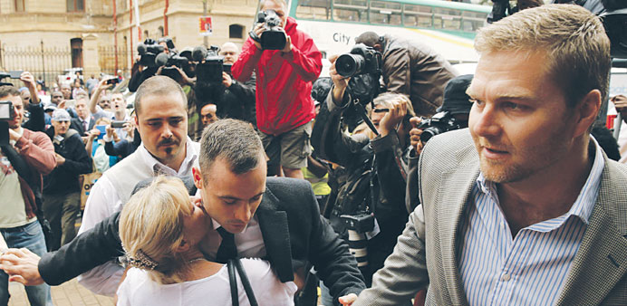 Oscar Pistorius is hugged by a supporter as he arrives at the high court in Pretoria.