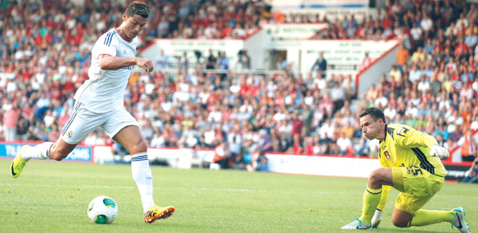Real Madridu2019s Cristiano Ronaldo (left) runs to score his second goal past Bournemouthu2019s goalkeeper Darryl Flahavan during their friendly match at Dean