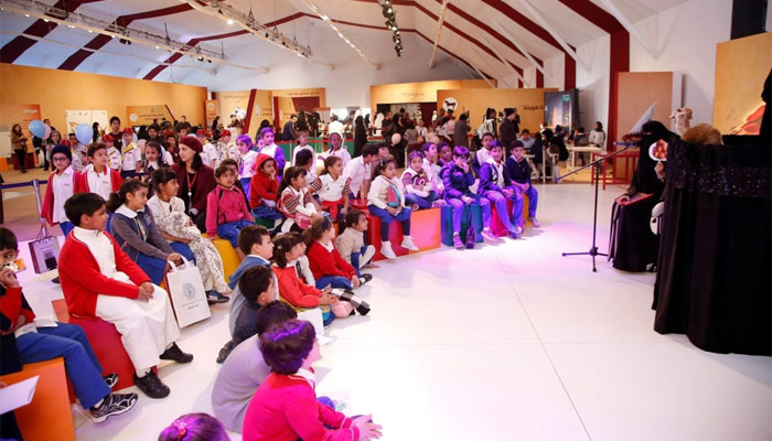 Children watching a puppet show in the QF tent at Darb Al Saai.