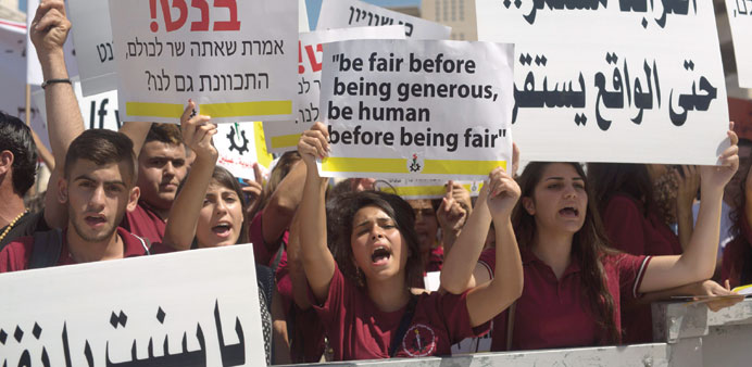 Arab Israeli Christian students hold placards during the protest in Jerusalem yesterday.