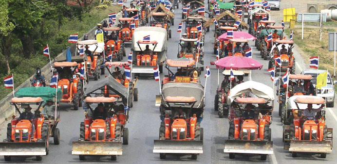 Farmers drive their tractors and other farming vehicles on a road in Ang Thong province, towards Bangkok yesterday.