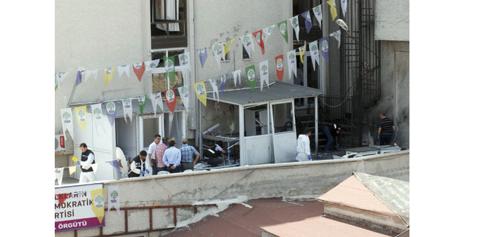 Forensic experts and plainclothes police officers examine the site of an explosion at an office of pro-Kurdish Peoplesu2019 Democratic Party (HDP) in Mers