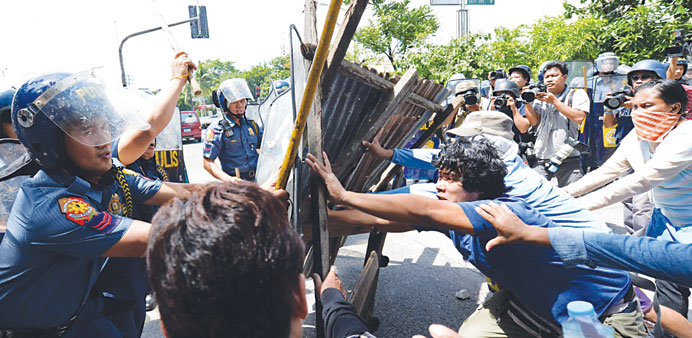 Informal settlers clash with anti-riot police in Manila yesterday after residents blocked a road in anticipation of the demolition of their homes.
