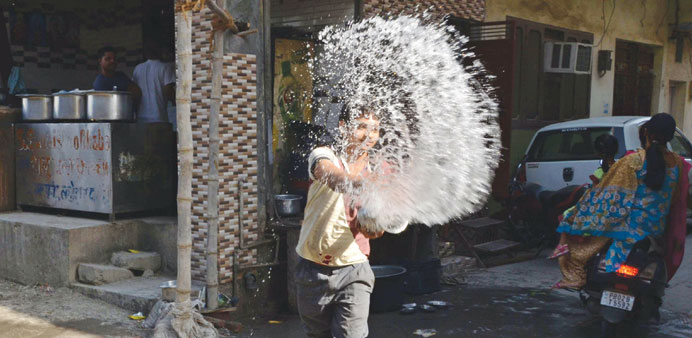 A worker throws water outside a restaurant in Amritsar yesterday in an attempt to keep the pavement cool on a hot day. At least 800 people have died i