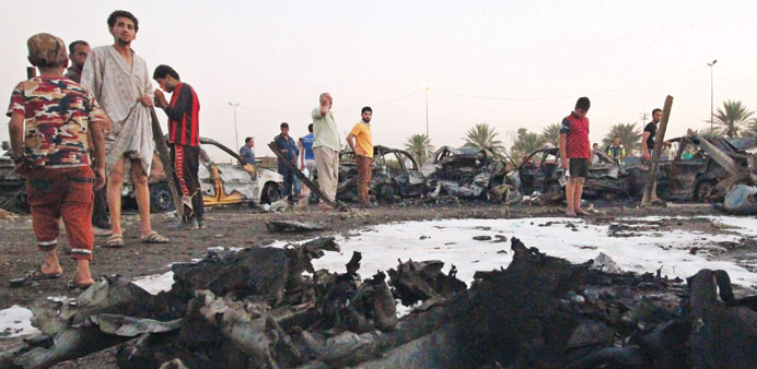 People look at the damage following a car bombing at a vehicle market in Baghdadu2019s Shia district of Sadr City yesterday.