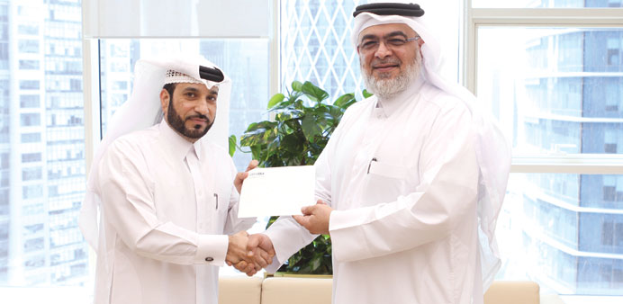 Mohamed Sharif al-Mushiri handing over a cheque to Mohamed al-Binali.