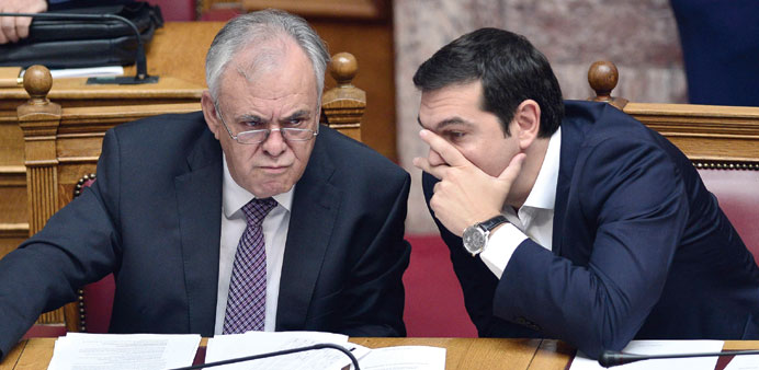 Greek Prime Minister Alexis Tsipras talks to Deputy Prime Minister Yiannis Dragasakis during the swearing-in ceremony of new deputies to the Greek par