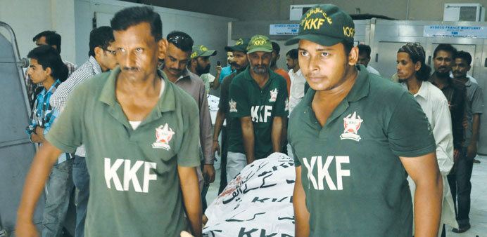 Rescuers carry the body of a victim who was killed in Karachi. Reports state that four people were gunned down by unknown assailants in Ghazi Nagar ar