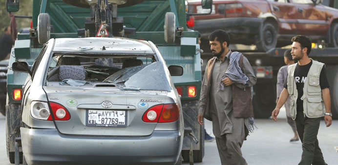 Damaged cars are moved away from the site of a car bomb blast in Kabul on Saturday.