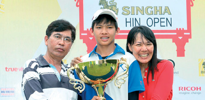Thailandu2019s Phachara Khongwatmai (centre) posing with his parents and the trophy after winning the Singha Hua Hin Open on the ASEAN PGA Tour. (AFP)