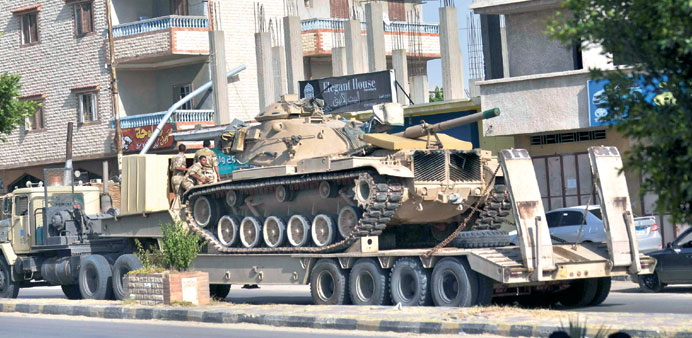 A military truck carries a tank through Sheikh Zowied town near Rafah yesterday to be deployed in El Ahrash in the northern Sinai.