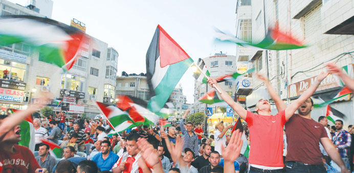 Palestinians celebrate in Ramallah yesterday after Palestine qualified for their maiden Asian Cup appearance by winning the AFC Challenge Cup in the M