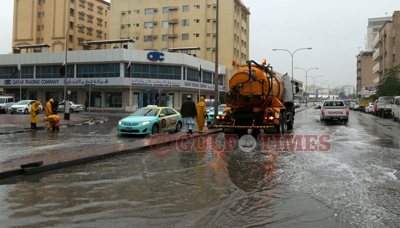 Rain emergency task force members deploying a suction tanker on a Doha road. PICTURE: Jayaram
