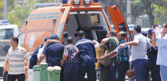 People injured in bomb blasts are transported to an ambulance in Cairo yesterday.