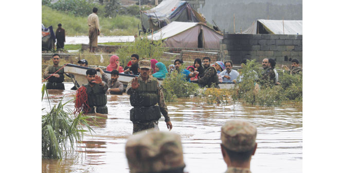 Soldiers gesturing as they evacuated flood-affected residents by boat on the outskirts of Islamabad yesterday.
