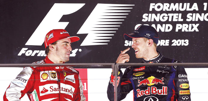 TWO GOOD: Red Bullu2019s Sebastian Vettel (right) talks with second-placed Fernando Alonso of Ferrari on the podium after yesterdayu2019s Singapore Grand Prix