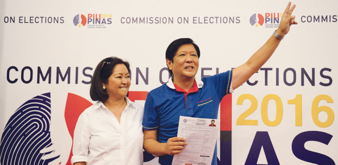 Ferdinand Marcos Jr, son of the late Philippine dictator Ferdinand Marcos gestures as he stands next to his wife, while holding his Certificate of Can