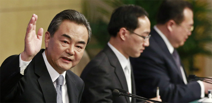Chinese Foreign Minister Wang Yi (L) waves at a news conference