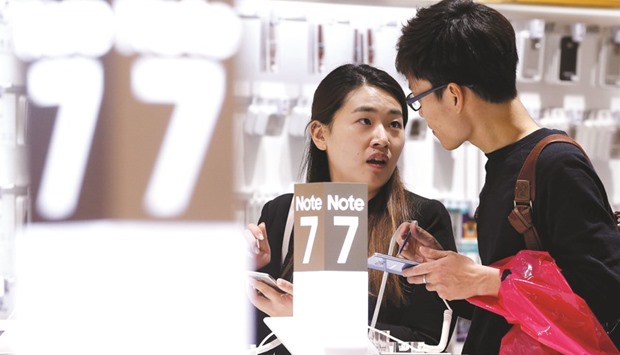 A couple tries out Samsungu2019s Galaxy Note 7 at the companyu2019s headquarters in Seoul. Top US and Australian carriers suspended sales or exchanges of Note 7s, while major airlines reiterated bans on passengers using the phones, after smoke from a replacement device forced the evacuation of a passenger plane in the US last week.