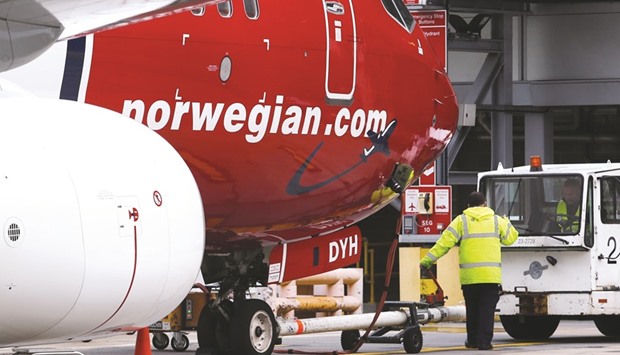 Members of the ground crew prepare to move an aircraft operated by Norwegian Air Shuttle ASA, at a departure gate at London Gatwick airport in Crawley. Norwegian Air Shuttle is evaluating plans for a base in Buenos Aires with flights from cities including Oslo, London, Paris, Madrid and Barcelona as the next phase of its long-haul, low-cost expansion strategy.