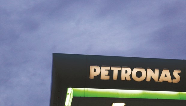 A logo of a Petronas fuel station is seen against a darkening sky in Kuala Lumpur.  The Malaysian state oil firm is considering selling its majority stake in a $27bn Canadian liquefied natural gas as a more than 50% slide in crude oil prices since the middle of 2014 has hit the groupu2019s profits and prompted cuts to capital expenditure and jobs.