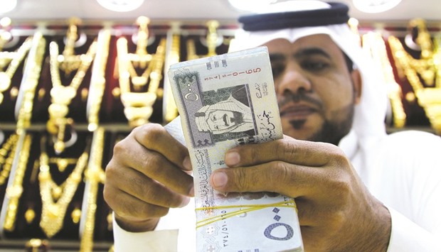 A Saudi man counts money at a jewellery shop in Riyadh. Saudi Arabiau2019s gross domestic product, adjusted for inflation, rose 1.4% from a year earlier in the second quarter of 2016, after growth of 1.5% in the first quarter, government data showed yesterday.