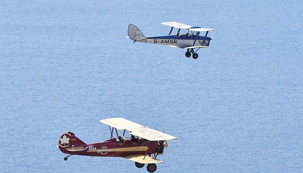 A Tiger Moth (top) and a Travel Air 4000 biplane fly during a photocall for the launch of the Vintage Air Rally off the coast of Shoreham, Sussex.