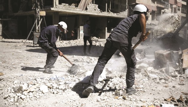 Syrian civil defence volunteers, known as the White Helmets, working at the site of an air strike in the rebel-held town of Douma, on the eastern outskirts of the capital Damascus.